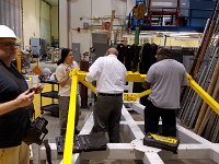 George Jacobs with crane controls and Brian Eng, Marc McMullen, and Amrit Yegneswaran tightening bolts of stiffening tool.