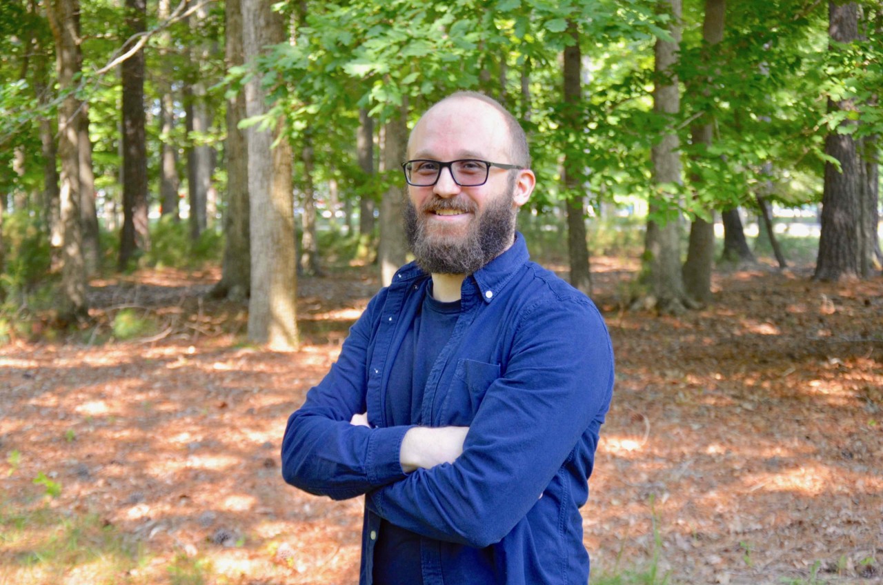 JSA 2018 Postdoc Prize Winner Cristiano Fanelli, standing in front of a wooded area