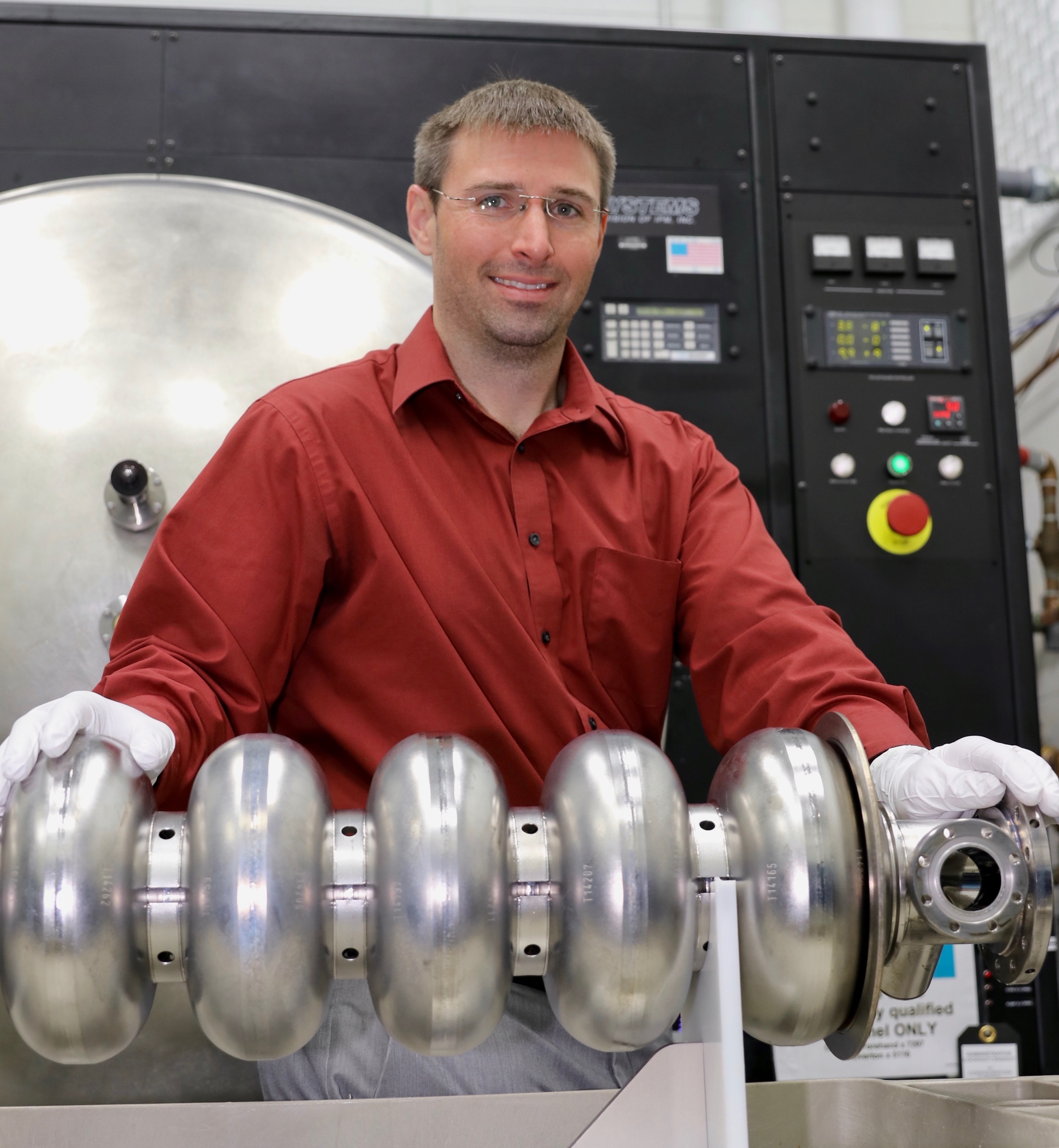Ari Palczewski shows a superconducting radiofrequency accelerator component