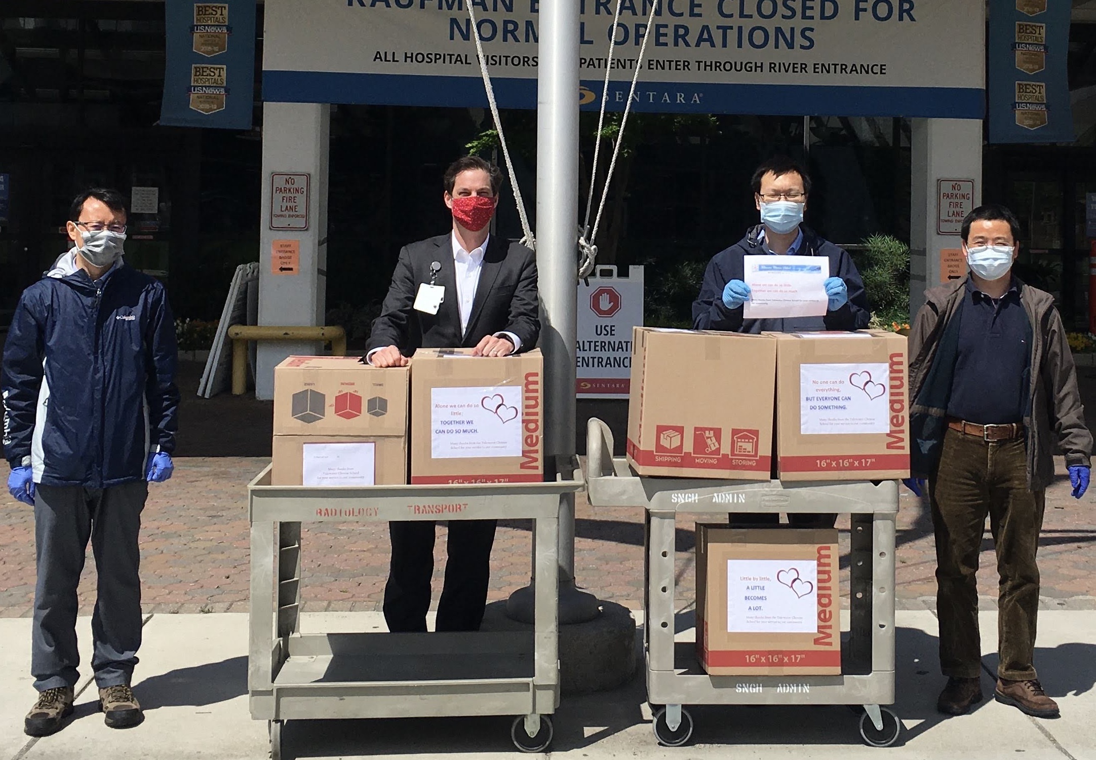 Members of the Peninsula Chinese American Association and the Tidewater Chinese School show boxes of supplies donated at local hospital.