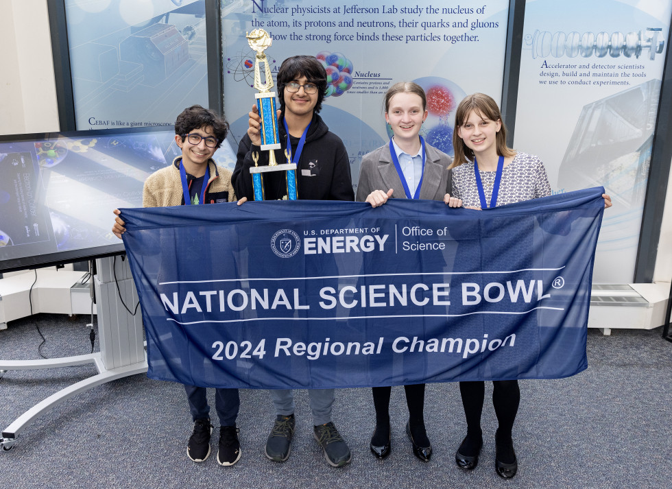 A group of students holding a trophy and a banner. 