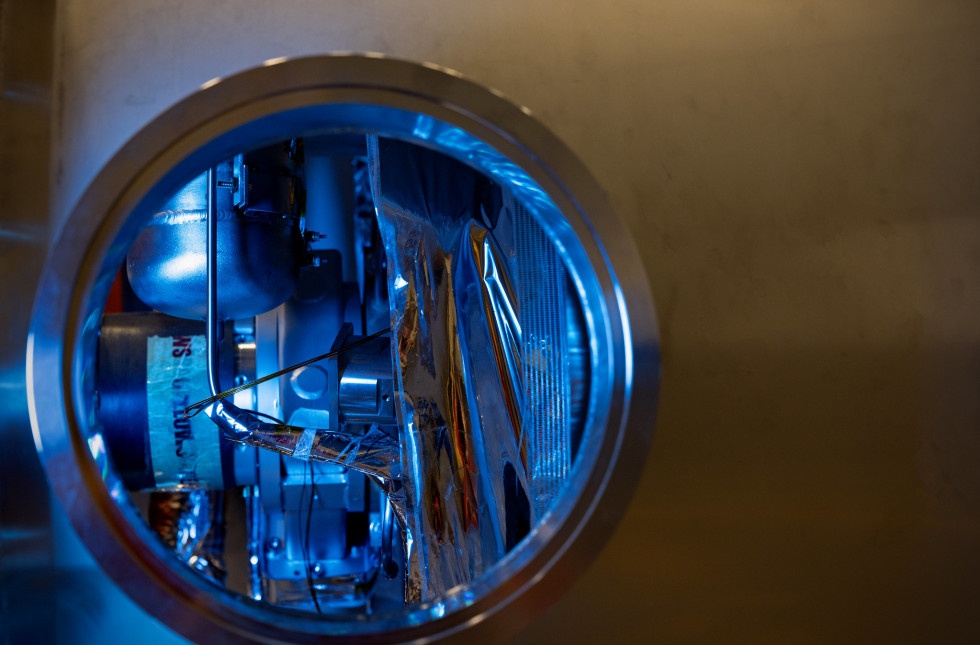 Blue light reflects off metallic surface details inside the Spallation Neutron Source Power Proton Upgrade cryomodule inside the SRF Institute at Jefferson Lab in Newport News. 