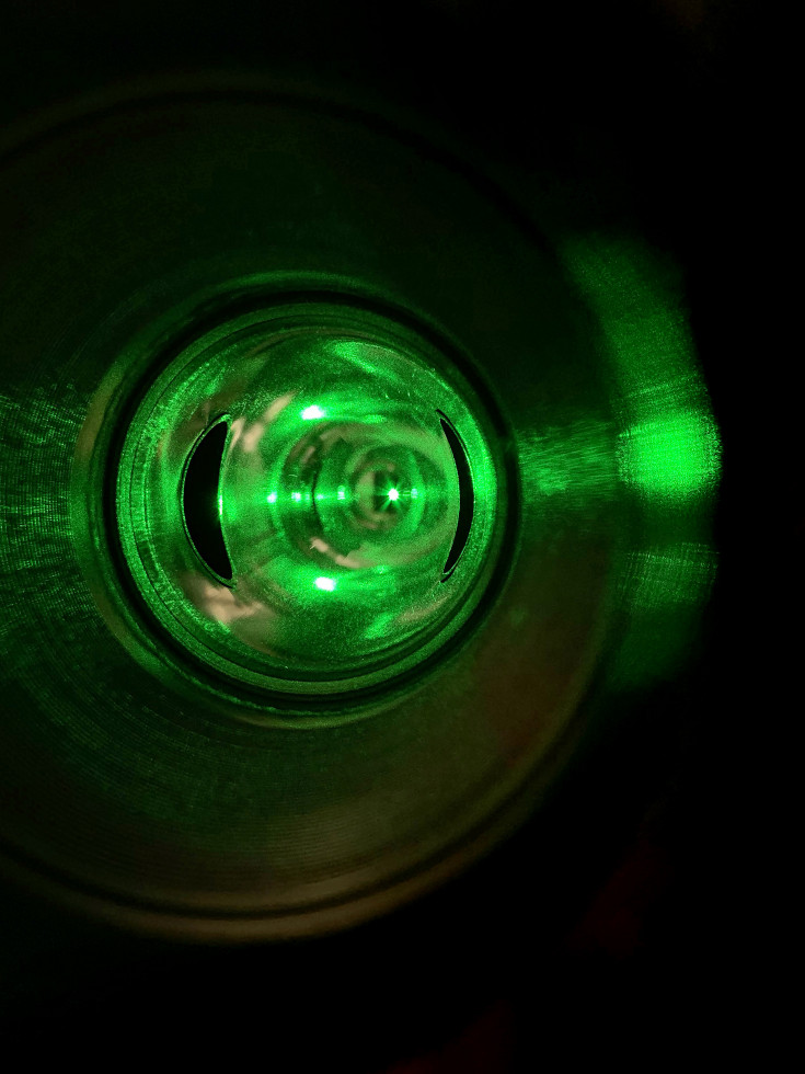 The Compton polarimeter’s green laser system, used to measure the parallel spin of electrons, shines during the running of the Calcium Radius Experiment in Hall A of the Continuous Electron Beam Accelerator Facility at Jefferson Lab.