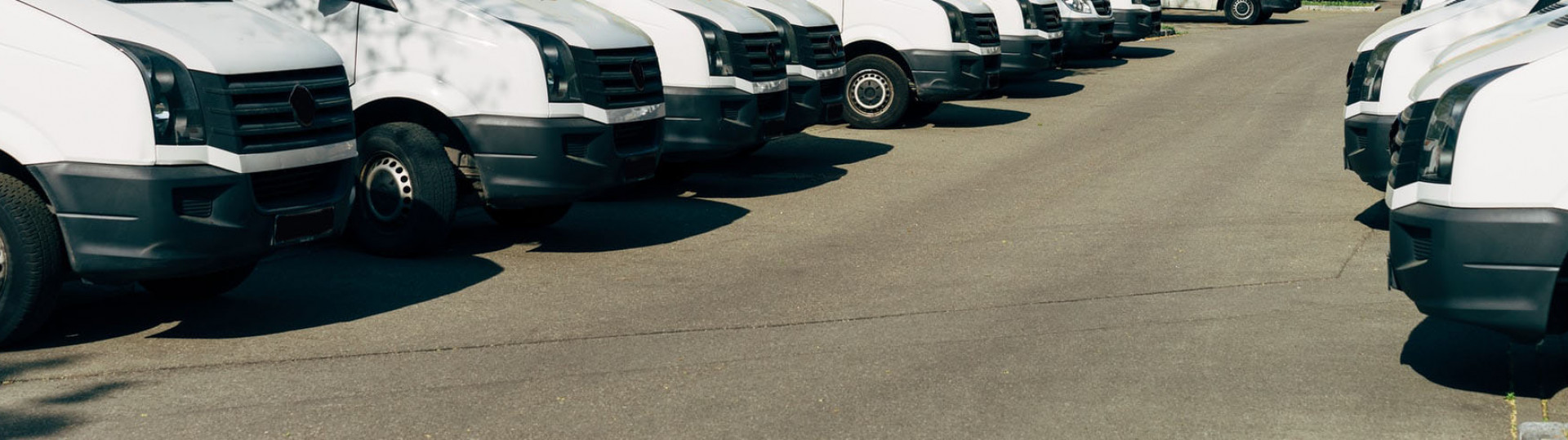 A generic photo of a parking lot of white vans used to represent a fleet of vehicles