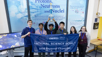 A group of students holding a trophy and a banner. 