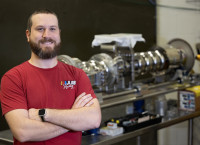 Mike Murphy stands in front of particle accelerator components