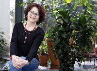 Patrizia Rossi poses in front of decorative plants at Jefferson Lab