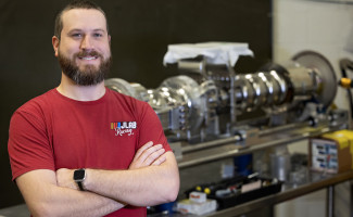 Mike Murphy stands in front of particle accelerator components