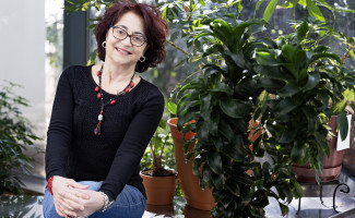 Patrizia Rossi poses in front of decorative plants at Jefferson Lab