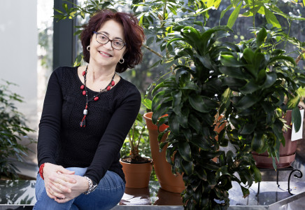 Patrizia Rossi poses in front of decorative plants at Jefferson Lab