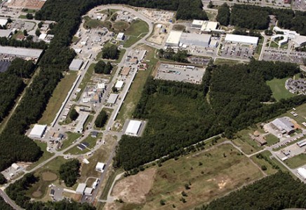An overhead view of Jefferson Lab showing the racetrack-shaped accelerator and experimental halls to the left