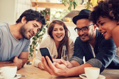 Group of diverse people looking at smartphone