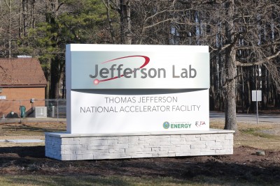 Jefferson Lab sign, metal with lab logo, white panels with full lab name installed on stone base.