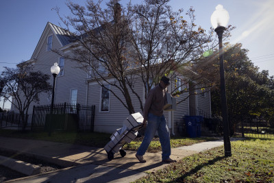 Newsome House Museum & Cultural Center’s Museum Assistant James Pope carries Hollinger archives boxes into the Newsome House storage area in Newport News, Va. Jefferson Lab gifted approximately 44 archival boxes to the Newsome House on Friday, Dec. 16, 2022. (Photo by Aileen Devlin | Jefferson La
