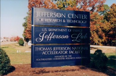 Old JLab sign - blue background with gold lettering, old lab logo lettering