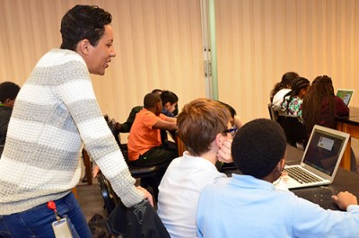Dana Cochran, Jefferson Lab staff member, helps students as they participate in a coding activity.